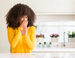 woman covering her nose because of smelly drains